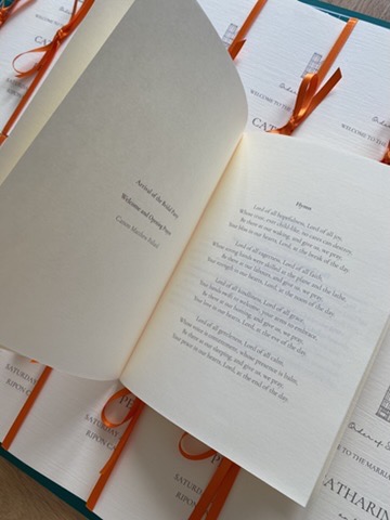Open order of service booklet showing hymn text and ceremony details